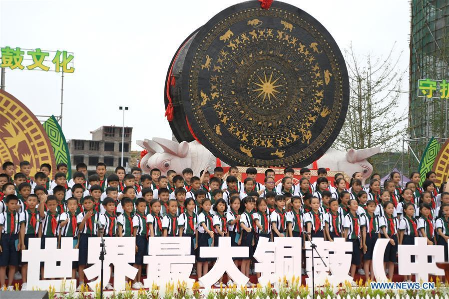 <?php echo strip_tags(addslashes(People celebrate beside a gigantic bronze drum in Huanjiang Maonan Autonomous County, south China's Guangxi Zhuang Autonomous Region, June 29, 2018. The drum measures 6.68 meters in diameter and weighs 50 tons. It was recognized as the largest bronze drum by Guinness World Records. (Xinhua/Zhou Hua))) ?>