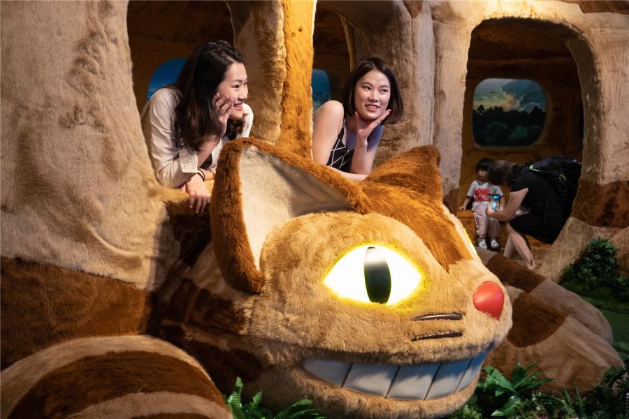 Visitors take a ride in the Tatsuo\'s bus featured in My Neighbor Totoro. (Photo/chinadaily.com.cn)