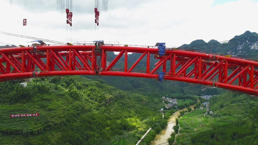 The last section is put into the position to finish the main span of the Daxiaojing Bridge in Guizhou Province, June 30, 2018.  (Photo//chinadaily.com.cn)