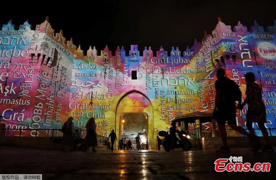 People stand near Damascus Gate outside Jerusalem\'s Old City as it is projected with images during the annual Light Festival, June 28, 2018. (Photo/Agencies)