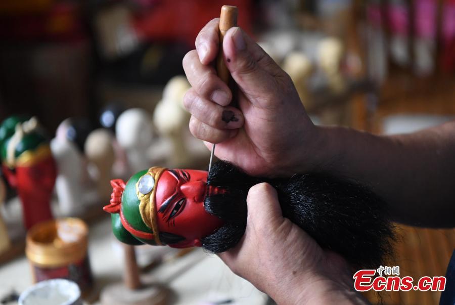 Folk artist Yang Yazhou adds a beard to the head of a puppet in his studio in Zhangzhou City, East China’s Fujian Province, July 1, 2018. Zhangzhou has a history of puppetry going back more than two thousand years. Yang represents the fifth generation of his family to be involved with Fuchun-style glove puppets show, an intangible cultural heritage. He began learning to carve puppet heads when he was nine years old, taught by several masters. Yang said it takes tens of steps to finish carving a puppet-head in about three days. Yang’s sister specializes in dressing the puppets, his brother in puppet performance. (Photo: China News Service/Zhang Bin)