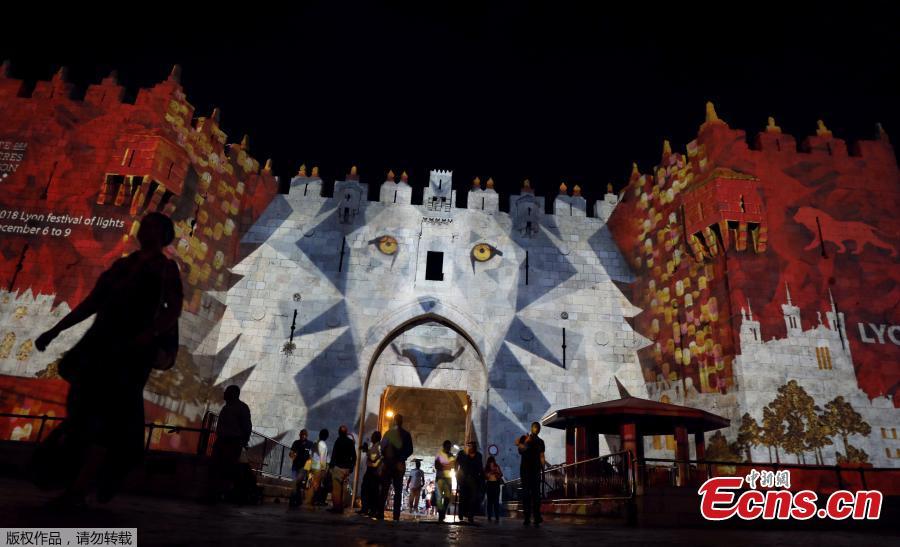 People stand near Damascus Gate outside Jerusalem\'s Old City as it is projected with images during the annual Light Festival, June 28, 2018. (Photo/Agencies)