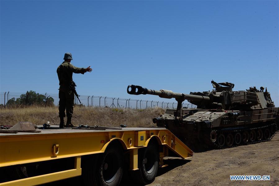 An Israeli tank moves onto a vehicle near the ceasefire line with Syria on the Israeli-occupied Golan Heights on July 1, 2018. The Israel Defense Forces (IDF) deployed additional tanks and artillery on the Golan Heights. (Xinhua/Ayal Margolin-JINI)