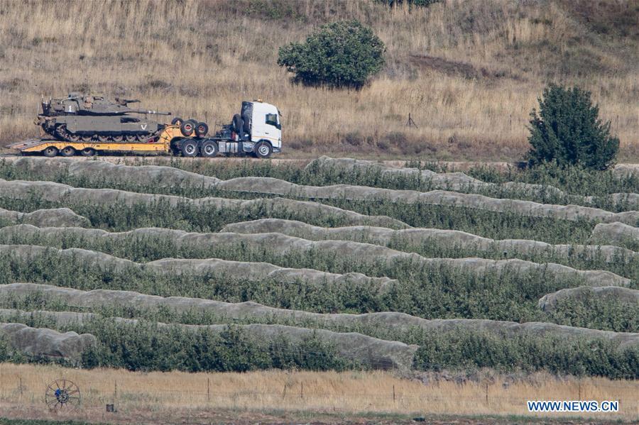 An Israeli tank is carried by a vehicle near the ceasefire line with Syria on the Israeli-occupied Golan Heights on July 1, 2018. The Israel Defense Forces (IDF) deployed additional tanks and artillery on the Golan Heights. (Xinhua/Ayal Margolin-JINI)
