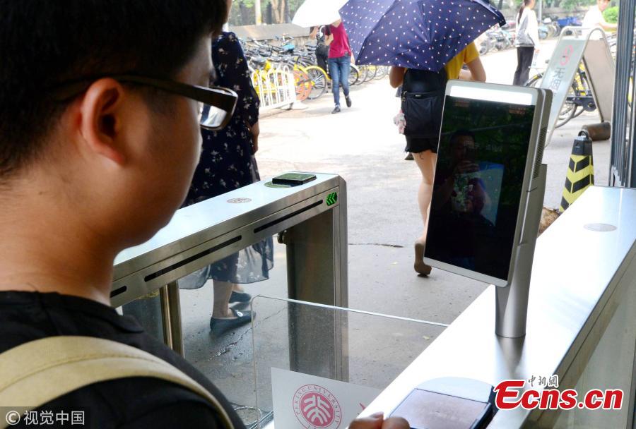 A student undergoes a facial recognition test before entering a school gate at Peking University in Beijing, July 3, 2018. Peking University is the first in China to adopt such a more powerful facial recognition system, capable of accurately and efficiently comparing one person’s facial data with the information of many others. (Photo/VCG)