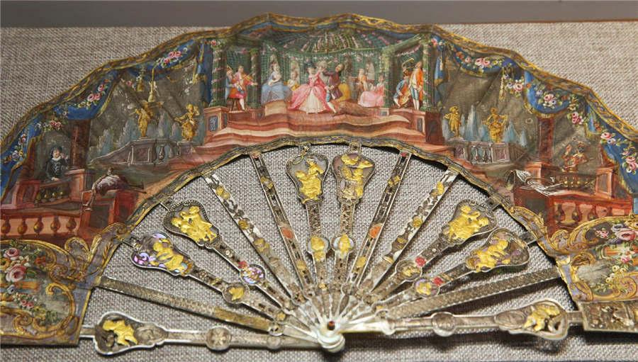 A paper fan decorated with pearls, glass and metals and made in France.  (Photo/China Daily)