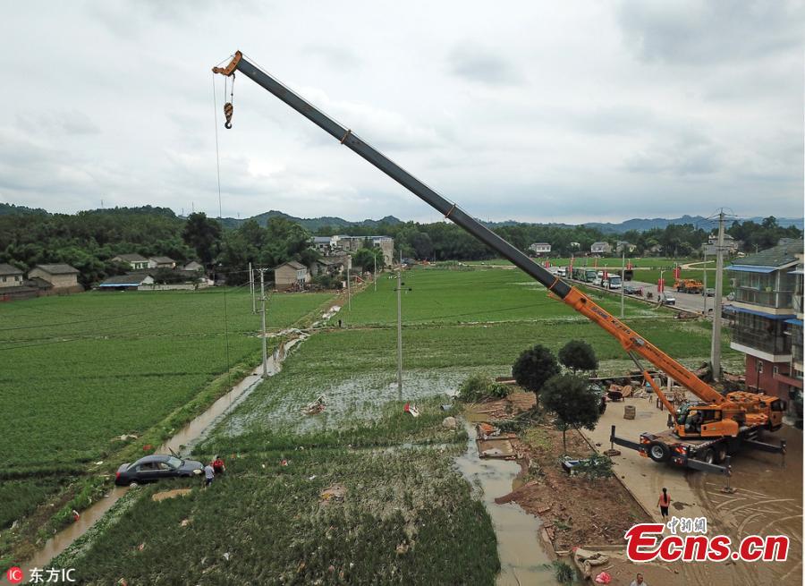 A crane is used to lift a car from a rice paddy field in Huilong Town, Southwest China’s Sichuan Province, July 3, 2018. (Photo/IC)