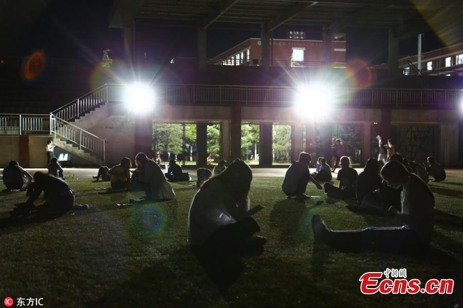 Students prepare for semester final exams on the football field of Qujing Medical College in Southwest China’s Yunnan Province, July 4, 2018. Students used flashlights on their mobile phones, small chargeable table lamps, and the lights of the football field to help them revise outside on what was a hot summer night. (Photo/IC)