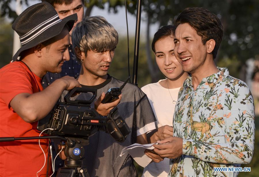 Daodao (1st R) and director Hezreteli Yasin (2nd L) who also acts in the comedy discuss scripts in Urumqi, northwest China\'s Xinjiang Uygur Autonomous Region, July 27, 2016. (Xinhua/Wang Fei)