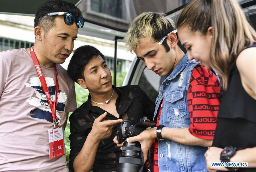 Daodao (2nd L) watches footage with other cast and crew members in Urumqi, northwest China\'s Xinjiang Uygur Autonomous Region, June 7, 2018. (Xinhua/Wang Fei)