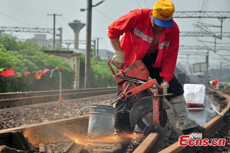 A worker races against time to repair the tracks on the Beijing-Kowloon railway in Gongqingcheng City, Jiangxi Province, July 4, 2018, after temperatures reached 30 degrees centigrade. The maintenance work had to be completed in two hours to minimize impact on the busy railway line. (Photo: China News Service/Wang Hao)