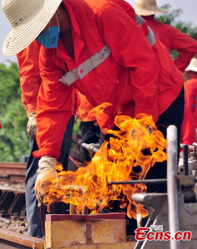 Workers race against time to repair the tracks on the Beijing-Kowloon railway in Gongqingcheng City, Jiangxi Province, July 4, 2018, after temperatures reached 30 degrees centigrade. The maintenance work had to be completed in two hours to minimize impact on the busy railway line. (Photo: China News Service/Wang Hao)