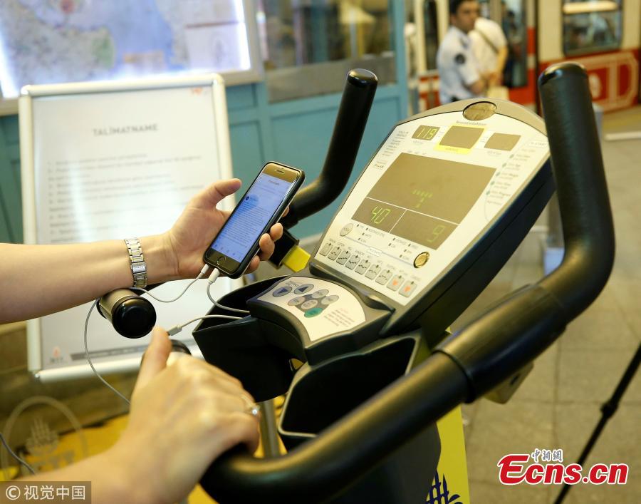 A woman uses a bicycle pedal power generator which was installed by the IETT (Istanbul electric tramway and tunnel establishments) at the Tunnel railway station to charge her mobile phone in Istanbul, Turkey, July 05, 2018. (Photo/Agencies)