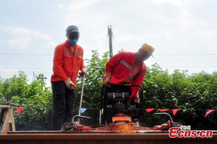 Workers race against time to repair the tracks on the Beijing-Kowloon railway in Gongqingcheng City, Jiangxi Province, July 4, 2018, after temperatures reached 30 degrees centigrade. The maintenance work had to be completed in two hours to minimize impact on the busy railway line. (Photo: China News Service/Wang Hao)