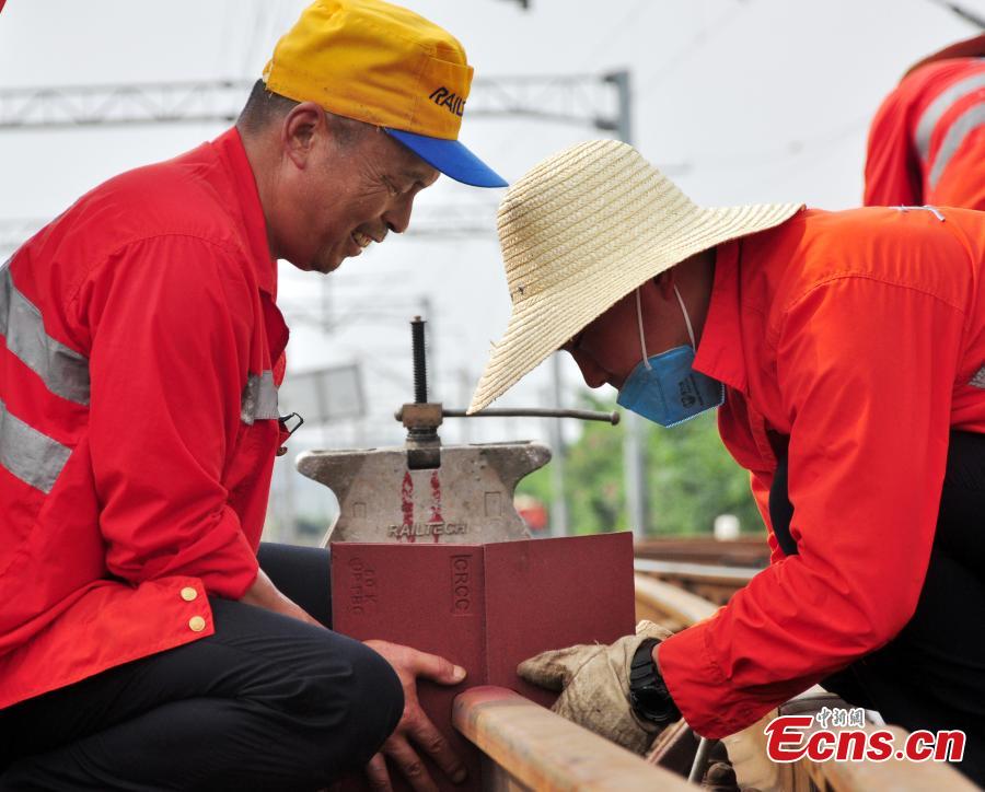 Workers race against time to repair the tracks on the Beijing-Kowloon railway in Gongqingcheng City, Jiangxi Province, July 4, 2018, after temperatures reached 30 degrees centigrade. The maintenance work had to be completed in two hours to minimize impact on the busy railway line. (Photo: China News Service/Wang Hao)