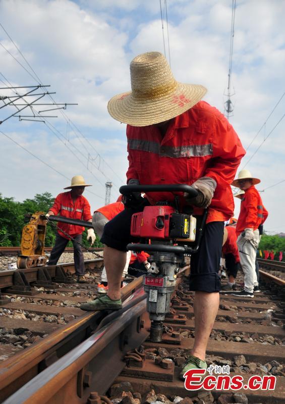 Workers race against time to repair the tracks on the Beijing-Kowloon railway in Gongqingcheng City, Jiangxi Province, July 4, 2018, after temperatures reached 30 degrees centigrade. The maintenance work had to be completed in two hours to minimize impact on the busy railway line. (Photo: China News Service/Wang Hao)