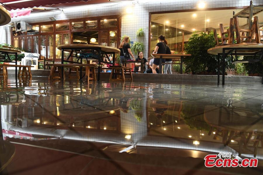 Diners enjoy hotpot while dipping their feet in a pool at a restaurant in Chongqing, July 5, 2018. Gold fish are kept in the pool, which allows customers to enjoy a footbath while eating the popular stew, a hot meal mixed with meat and vegetables. (Photo: China News Service/Chen Chao)