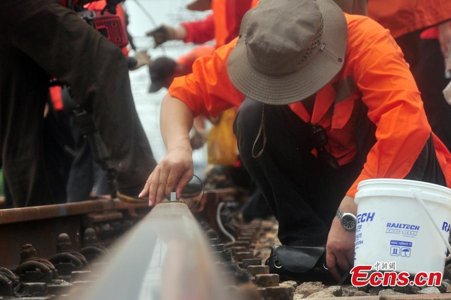 Workers race against time to repair the tracks on the Beijing-Kowloon railway in Gongqingcheng City, Jiangxi Province, July 4, 2018, after temperatures reached 30 degrees centigrade. The maintenance work had to be completed in two hours to minimize impact on the busy railway line. (Photo: China News Service/Wang Hao)