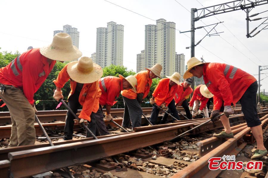 Workers race against time to repair the tracks on the Beijing-Kowloon railway in Gongqingcheng City, Jiangxi Province, July 4, 2018, after temperatures reached 30 degrees centigrade. The maintenance work had to be completed in two hours to minimize impact on the busy railway line. (Photo: China News Service/Wang Hao)