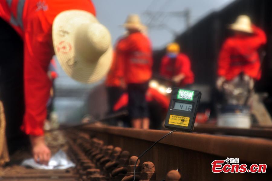 Workers race against time to repair the tracks on the Beijing-Kowloon railway in Gongqingcheng City, Jiangxi Province, July 4, 2018, after temperatures reached 30 degrees centigrade. The maintenance work had to be completed in two hours to minimize impact on the busy railway line. (Photo: China News Service/Wang Hao)