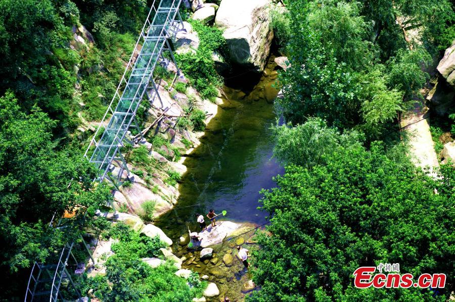 An aerial view of a waterslide over the Xiangma River in Lushan County, Central China’s Henan Province, July 9, 2018. The 2.3-kilometer-long waterside under construction around a mountain slope and cliff has a vertical drop of 100 meters, earning it the title of the longest and most challenging waterslide in central China. (Photo: China News Service/Dong Fei)