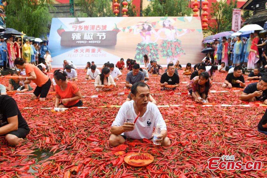 Participants chew chili peppers while immersed in a pool filled with peppers during a contest in Ningxiang City, Central China’s Hunan Province, July 8, 2018. Tang Shuaihui, a local resident, swallowed 50 chili peppers in one minute to win first prize. (Photo: China News Service/Yang Huafeng)