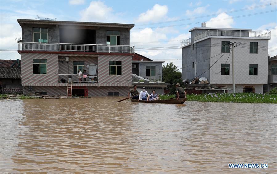 Residents take boat in flooded area in Qiaoxi Village of Maxu Township of Fuzhou City, east China\'s Jiangxi Province, July 8, 2018. Flood caused by heavy rain damaged crops and housings in Maxu Township and rescue groups were set up to help the affected people. (Xinhua/He Jianghua)