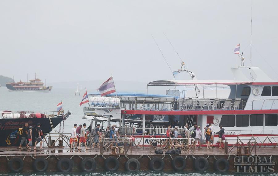 Tourists are ready to board a cruise ship at a pier in Phuket on July 9. About nine cruise ships left the port Monday morning. The Thai government issued a high wave warning in the range of 2-3 meters from July 7 to 12, but many tourists still chose to go on cruises. They said they are not worried about the safety and will wear life vests onboard. (Photo: Cui Meng/GT)