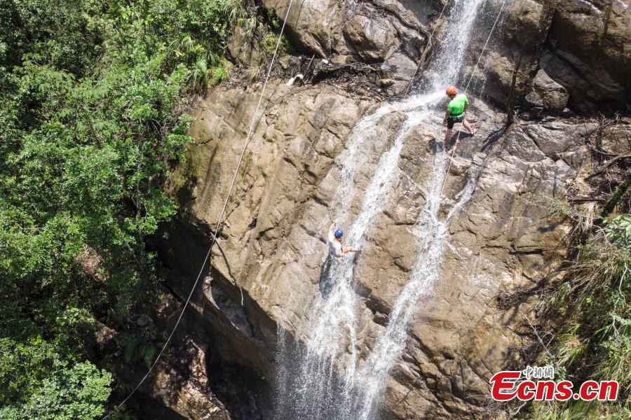 <?php echo strip_tags(addslashes(Two adventurers abseil down a 106-meter-high waterfall in Jiulong River National Park in Rucheng County, Central China’s Hunan Province, July 10, 2018. Two participants took five minutes to descend a rope from a glass walkway at the top of a cliff to the ground below. (Photo: China News Service/Yang Huafeng))) ?>