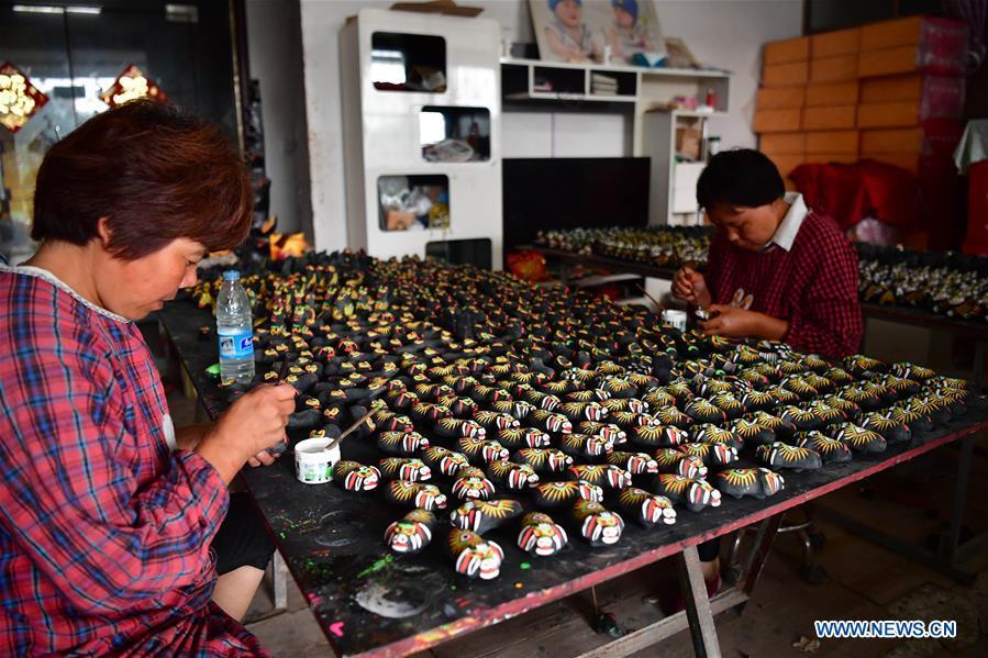 Local handicraftswomen make clay statuettes in Jinzhuang Village of Huaiyang County, central China\'s Henan Province, July 9, 2018. Originated from ancient sacrificial ceremonies, the hand-made clay statuette \
