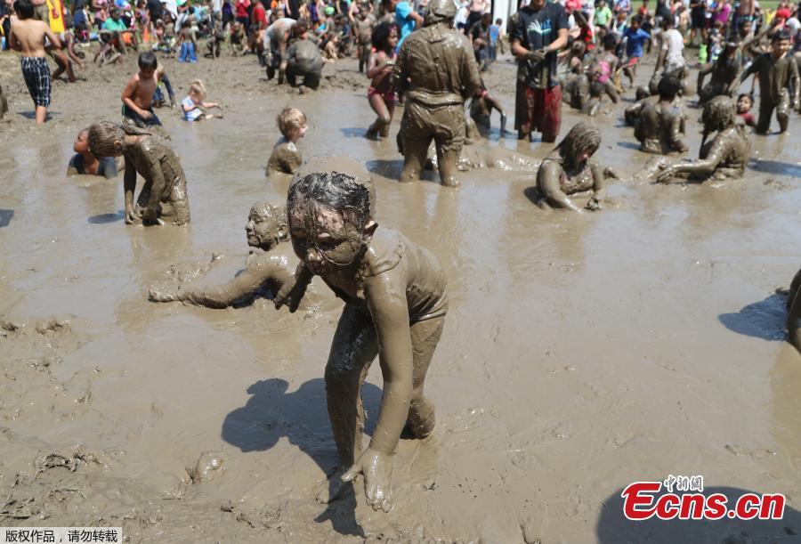 Lilly Fielauer, 5, exits the mud pit during Mud Day at the Nankin Mills Park, July 10, 2018, in Westland, Mich. The annual day sponsored by the Wayne County Parks takes place in a 75\' x 150\' giant mud pit that gives children the opportunity to get down and dirty at one of the messiest playgrounds Southeast Michigan has ever seen. (Photo/Agencies)