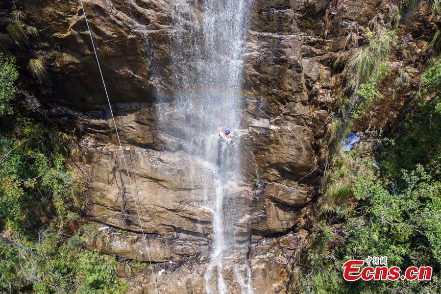 <?php echo strip_tags(addslashes(Two adventurers abseil down a 106-meter-high waterfall in Jiulong River National Park in Rucheng County, Central China’s Hunan Province, July 10, 2018. Two participants took five minutes to descend a rope from a glass walkway at the top of a cliff to the ground below. (Photo: China News Service/Yang Huafeng))) ?>