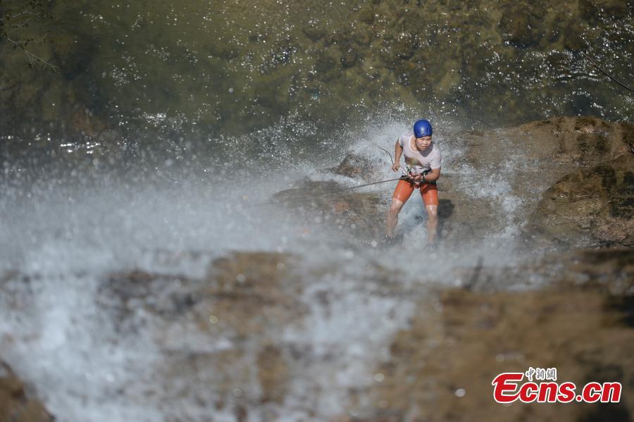 <?php echo strip_tags(addslashes(Sun Si abseils down a 106-meter-high waterfall in Jiulong River National Park in Rucheng County, Central China’s Hunan Province, July 10, 2018. Two participants took five minutes to descend a rope from a glass walkway at the top of a cliff to the ground below. (Photo: China News Service/Yang Huafeng))) ?>
