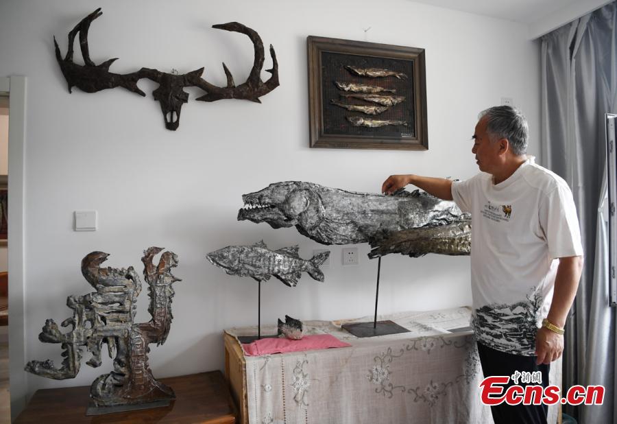 Sui Jincai, an art teacher, shows iron artworks in Changchun City, Jilin Province, July 11, 2018. Sui uses acrylic paints and iron materials to create vivid 3D creations. (Photo: China News Service/Zhang Yao)