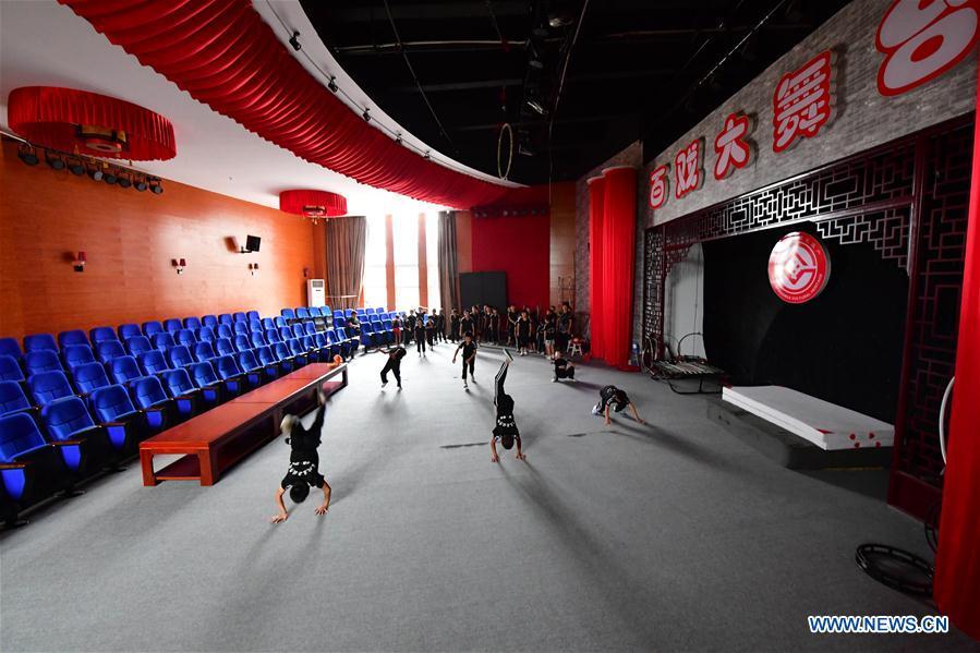 Trainees practice at an acrobatics school in Dongbeizhuang Village of Puyang, central China\'s Henan Province, July 11, 2018. In Dongbeizhuang Village, an acrobatics school enrols some 40 trainees aged between five and 15 who are faced with financial difficulties. The school offers both skills trainings and academic lessons but charges no tuition fees, preparing the trainees to join larger troupes with greater opportunities. (Xinhua/Feng Dapeng)