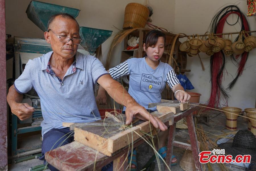 Yang Dujuan and Yang Guanglun, 65, prepare bamboo strips for a creation in Sansui County, Southwest China’s Guizhou Province, July 11, 2018. A former migrant worker, Yang began to lead other villagers to make bamboo creations in 2014, trained more than 300 locals, and has now reached annual sales surpassing one million yuan ($150,000). In 2018, she began offering bamboo strips made into QR codes for clients, a creative combination of traditional bamboo weaving and the emerging popularity of codes that smartphone users can scan to access rich information. Her creation priced at 200 yuan for products was popular online. (Photo: China News Service/He Junyi)