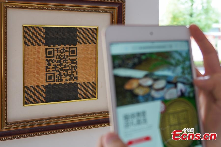 A visitor scans a QR code made from bamboo strips to access the online store of Yang Dujuan in Sansui County, Southwest China’s Guizhou Province, July 11, 2018. A former migrant worker, Yang began to lead other villagers to make bamboo creations in 2014, trained more than 300 locals, and has now reached annual sales surpassing one million yuan ($150,000). In 2018, she began offering bamboo strips made into QR codes for clients, a creative combination of traditional bamboo weaving and the emerging popularity of codes that smartphone users can scan to access rich information. Her creation priced at 200 yuan for products was popular online. (Photo: China News Service/He Junyi)