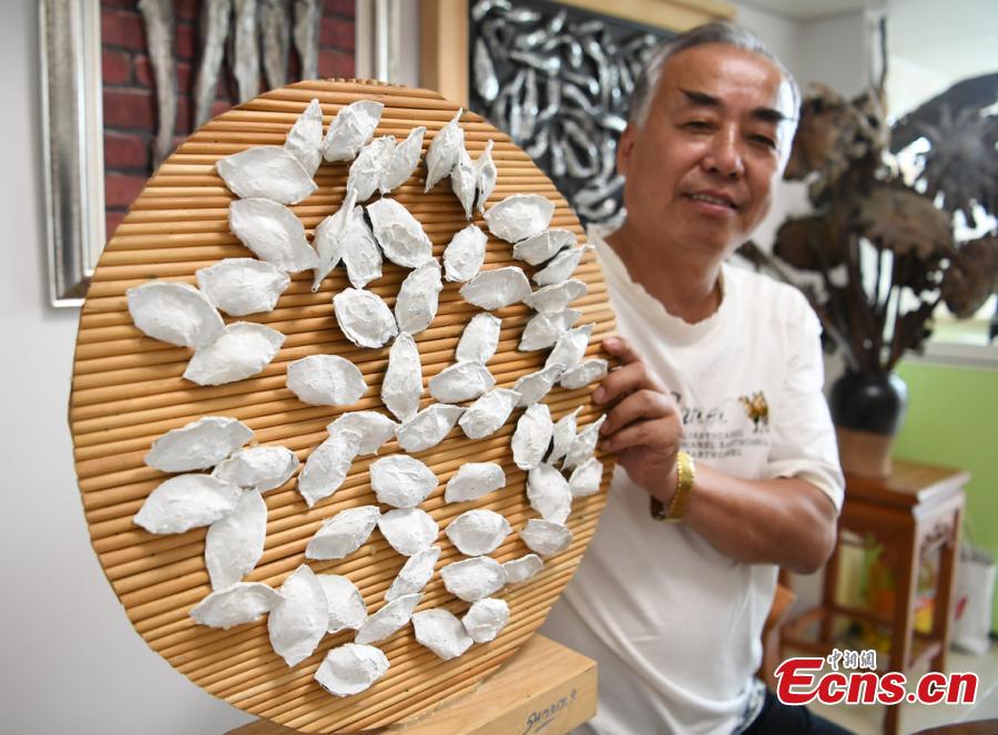 Sui Jincai, an art teacher, shows his dumpling-like iron artworks in Changchun City, Jilin Province, July 11, 2018. Sui uses acrylic paints and iron materials to create vivid 3D creations. (Photo: China News Service/Zhang Yao)