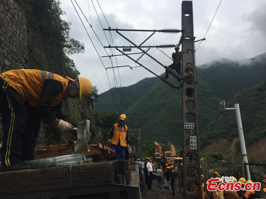 Rescuers work to clean up a landslide that cut off the Baoji-Chengdu railway line in Lueyang County, Northwest China’s Gansu Province, July 13, 2018 after continuous heavy rain. Local railway authorities have mobilized thousands of people to resume train operations. (Photo provided to China News Service)