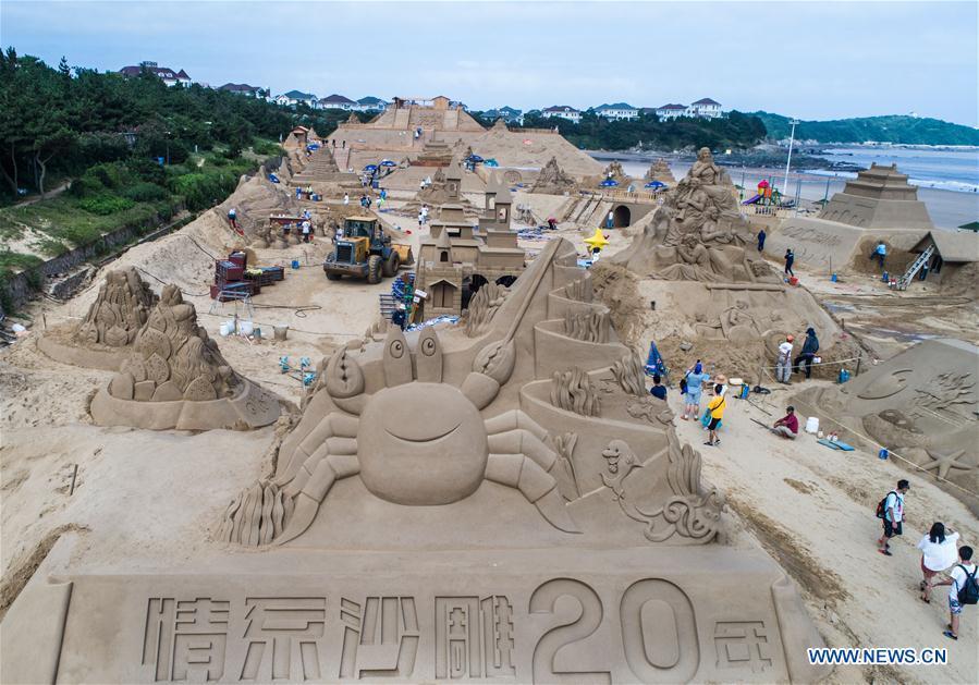 In this aerial photo taken on July 12, 2018, sand sculptors prepare their works for the upcoming 2018 Zhoushan International Sand Sculpture Festival in Zhoushan, east China\'s Zhejiang Province. The works of over 30 sand sculptors worldwide will be officially made available to public visitors on July 21. (Xinhua/Xu Yu)