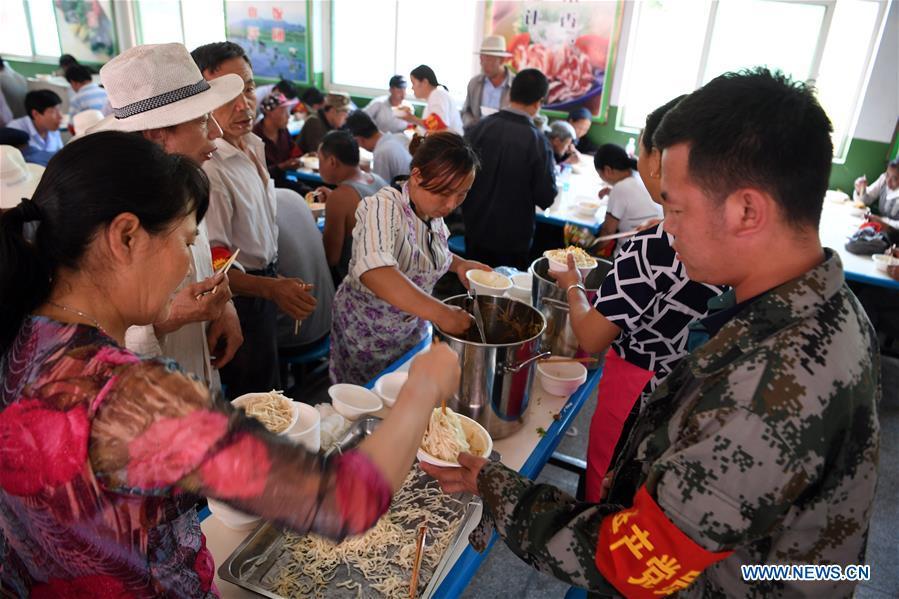 Affected residents dine at a relief center in Zhouqu County, northwest China\'s Gansu Province, July 14, 2018. A landslide occurred on Thursday at Nanyu Township of Zhouqu County due to continuous rainstorms. Rock and mud fell from mountain into the Bailong River, causing flooding in low-lying areas in neighboring Nanyi Village and Naner Village. No casualties have been reported and relief work is ongoing. (Xinhua/Fan Peishen)