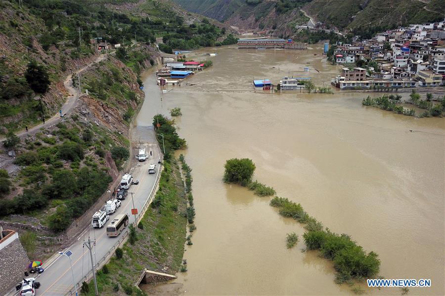 Aerial photo taken on July 14, 2018 shows the flooded Nanyi Village and Naner Village in Nanyu Township of Zhouqu County, northwest China\'s Gansu Province. A landslide occurred on Thursday at Nanyu Township of Zhouqu County due to continuous rainstorms. Rock and mud fell from mountain into the Bailong River, causing flooding in low-lying areas in neighboring Nanyi Village and Naner Village. No casualties have been reported and relief work is ongoing. (Xinhua/Fan Peishen)