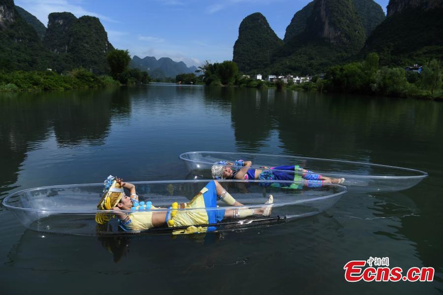 Performers lie on transparent boats as they rehearse for a show on the Lijiang River in Guilin City, South China’s Guangxi Zhuang Autonomous Region, July 15, 2018. (Photo: China News Service/Chen Chao)