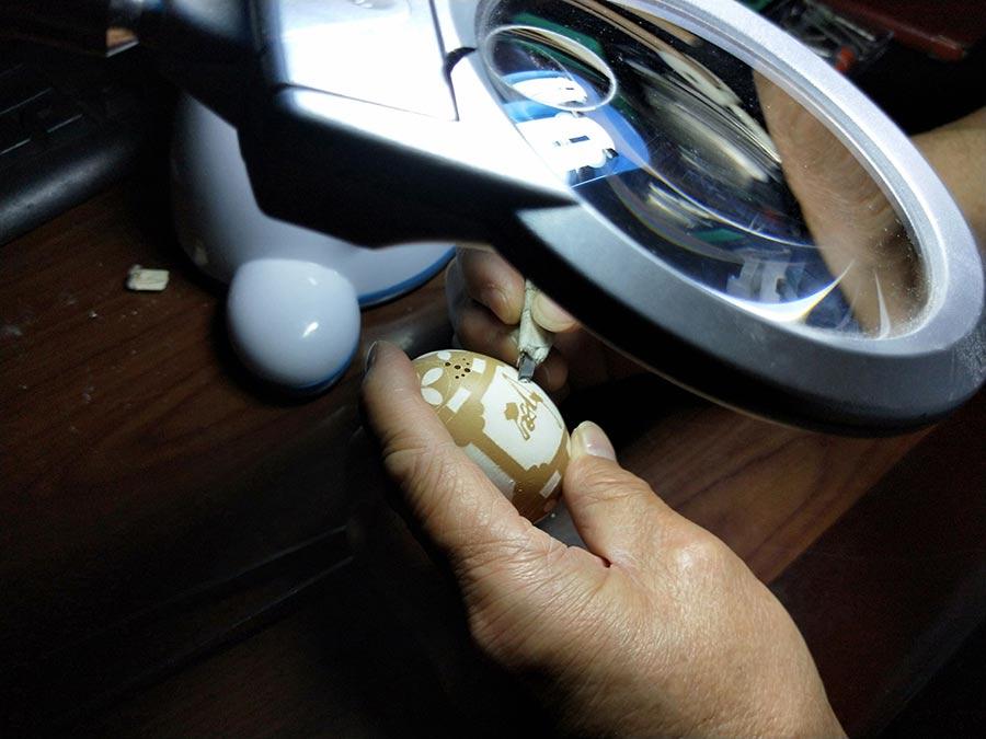 Tai Xinchu works on an egg carving. (Photo by Yao Daojun/for chinadaily.com.cn)