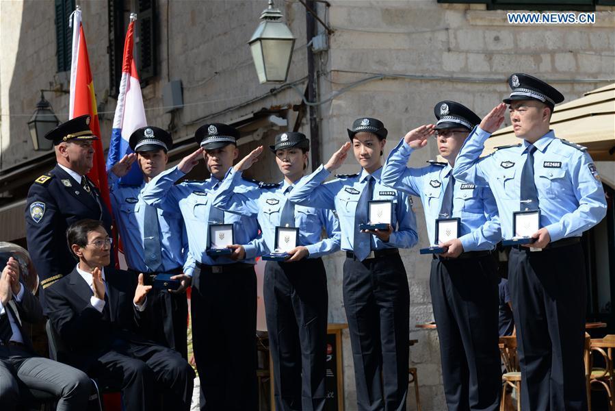 Zeljko Prsa, Deputy General Police Director of Croatia, gives police badges to Chinese police officers during the launching ceremony of joint police patrol between China and Croatia in Dubrovnik, Croatia, on July 15, 2018. Six uniformed Chinese police officers started joint patrol with their Croatian counterparts here on Sunday. (Xinhua/Gao Lei)