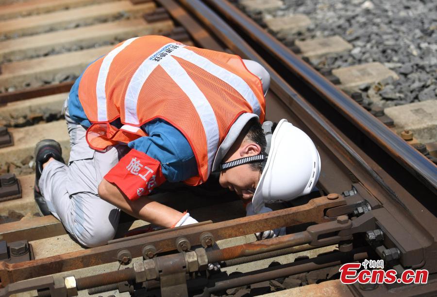 A signal inspection technician works on a railway track as temperatures reach a high of 36 degrees centigrade in Hangzhou City, East China’s Zhejiang Province, July 16, 2018. (Photo: China News Service/Wang Gang)
