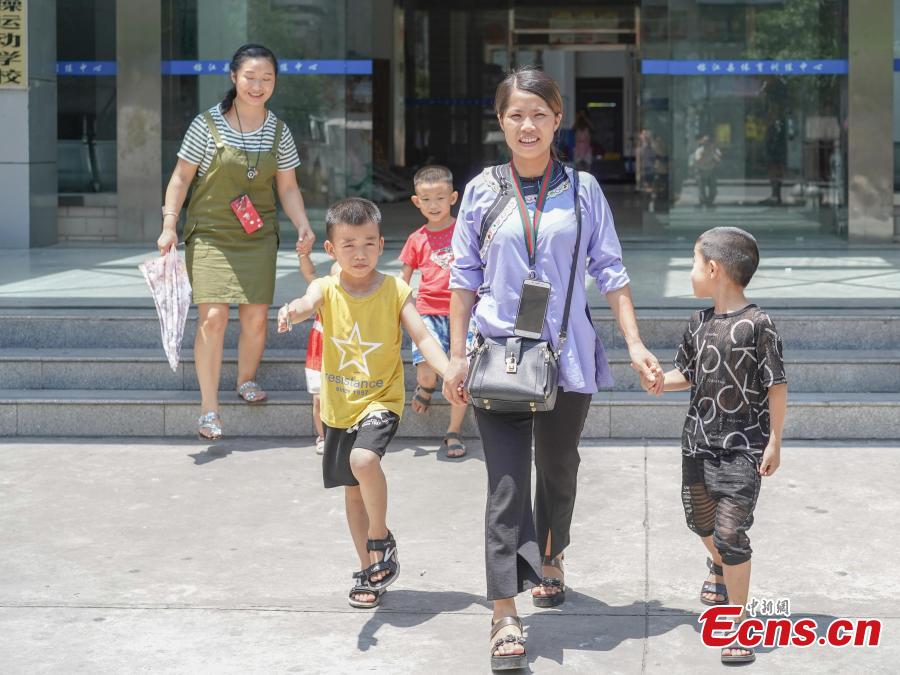Children walk with their mothers after finishing gymnastics training at the Amateur Children\'s Gymnastics Training School in Rongjiang County, Southwest China’s Guizhou Province, July 16, 2018. There are 60 children taking part in gymnastics training at the school during their spare time. Since 1972, the county has sent 21 athletes to the provincial gymnastics and gymnastics trampoline teams, among whom six later became national team members. The county is home to Liu Rongbing, who won a gold medal for the men\'s team in the 2014 World Artistic Gymnastics Championships. (Photo: China News Service/He Junyi)