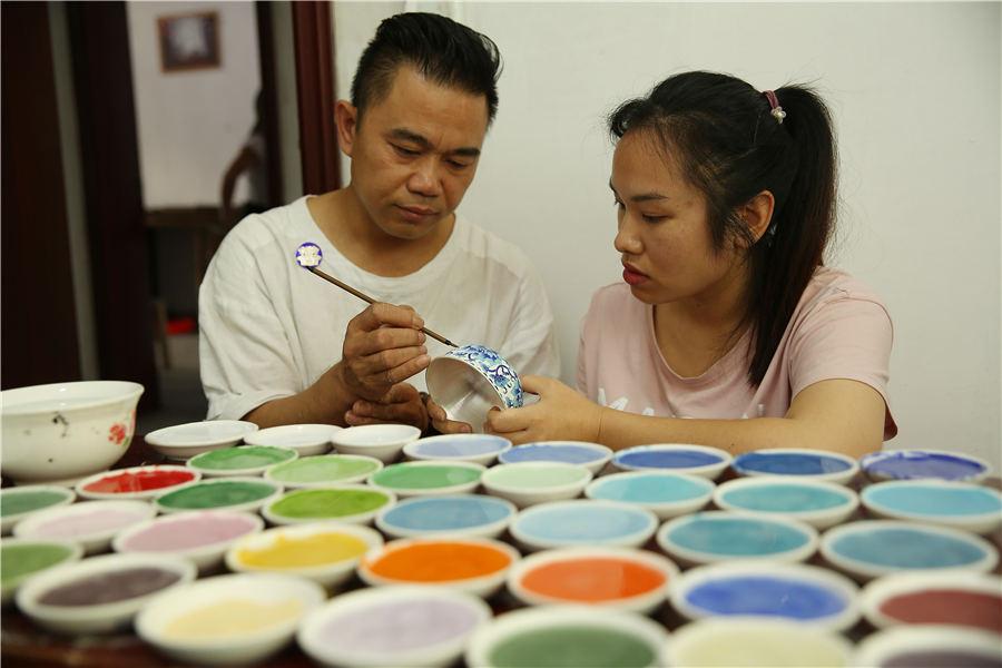 Wang demonstrates the glazing skill on a silver ware in his factory, Danzhai county, Southwest China\'s Guizhou Province, July 12, 2018.  (Photo//Asianewsphoto)
