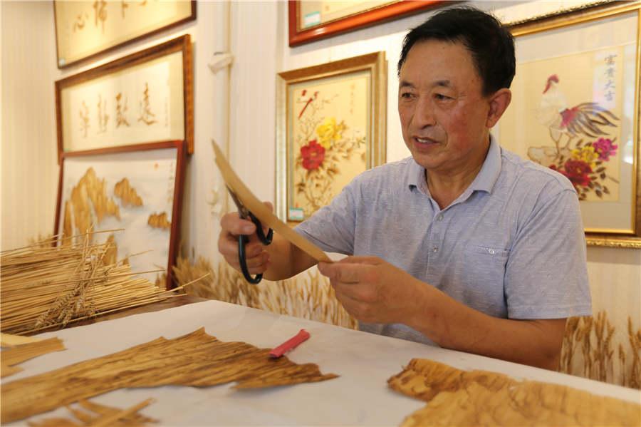 Ding Xisen works on a straw painting.  (Photo/Asianewsphoto)
