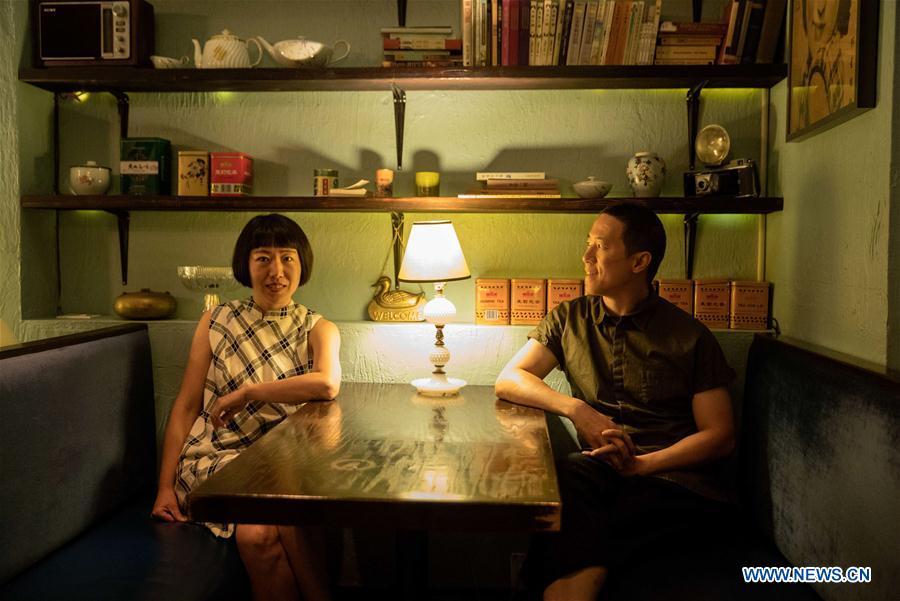 Restaurant owner Wang Yiming (L) and Zhang Xian are seen at Cafe China in New York, the United States, on June 27, 2018. Walking in the bustling street of midtown Manhattan, you may not notice Cafe China if there weren\'t so many people waiting for seats outside the Chinese restaurant. Although the space is limited and decoration not so luxury, Cafe China has won Michelin one star for six consecutive years from 2012 to 2017. Wang Yiming and Zhang Xian, a couple from China, quit their well-paid financial jobs in New York and opened Cafe China with the ambition to provide authentic Sichuan cuisine along with a comfortable dining environment. They decided not to sell American-Chinese dishes like most Chinese restaurants did at that time. Meanwhile, the couple decorated the place with items such as vintage posters, antique cameras and lamps to create an old Shanghai style. At the beginning, their idea was strongly opposed by many friends and even their staff, as the American-Chinese food was the easiest way to make money at that time. However, it surprised them that many Americans swarmed to Cafe China with curiosity for decent Chinese dishes and the unique dining environment as soon as the restaurant just opened. The couple believed the success of Cafe China resulted from not only the appeal of authentic Chinese food but also the sophisticated Chinese culture behind it. \